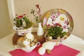 Osterdeko, buntes Porzellan mit Bellis, Eier, Kirschblüte